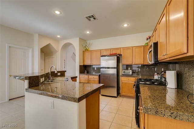 10952 Porto Foxi St, Las Vegas, NV 89141 - kitchen featuring stainless steel appliances, light tile patterned flooring, decorative backsplash, arched walkways, and recessed lighting