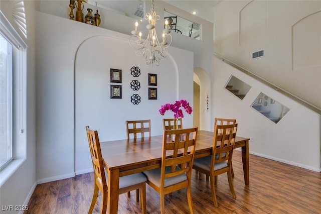 10952 Porto Foxi St, Las Vegas, NV 89141 - dining space featuring healthy amount of natural light, wood finished floors, a towering ceiling, a chandelier, and arched walkways