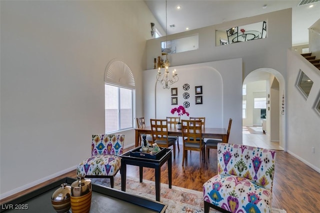 10952 Porto Foxi St, Las Vegas, NV 89141 - living area featuring arched walkways, healthy amount of natural light, a chandelier, a towering ceiling, and wood finished floors