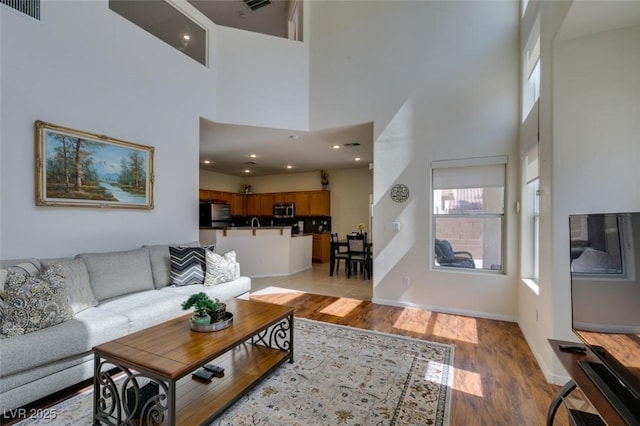 10952 Porto Foxi St, Las Vegas, NV 89141 - living room featuring light wood-style floors, a towering ceiling, and recessed lighting