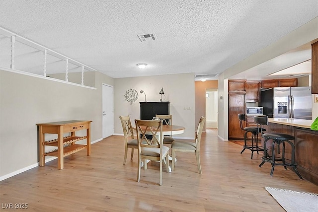 7113 Carrondale Way, Las Vegas, NV 89128 - dining area featuring a textured ceiling and light wood-type flooring