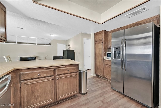 7113 Carrondale Way, Las Vegas, NV 89128 - kitchen with appliances with stainless steel finishes, light wood-type flooring, light countertops, and a desk