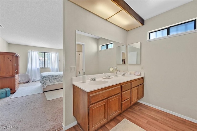 7113 Carrondale Way, Las Vegas, NV 89128 - ensuite bathroom featuring double vanity, plenty of natural light, and wood finished floors