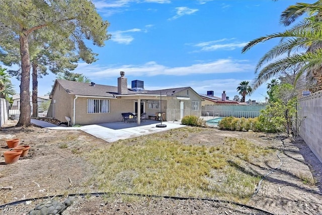 7113 Carrondale Way, Las Vegas, NV 89128 - back of property featuring stucco siding, a chimney, a patio area, and a fenced backyard