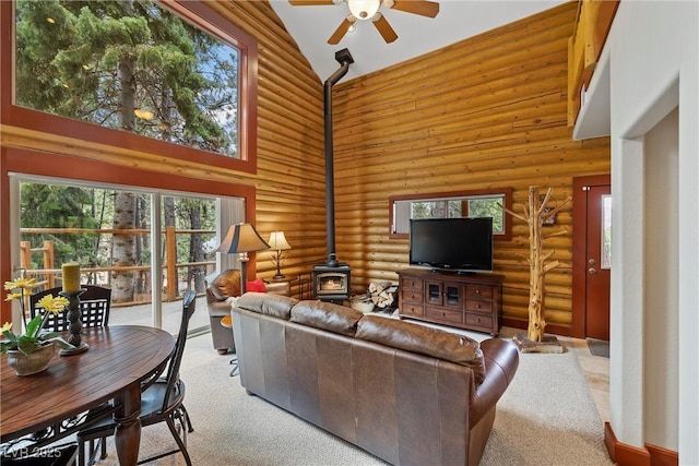 401 Alpine Way, Mount Charleston, NV 89124 - carpeted living room with a wood stove, high vaulted ceiling, ceiling fan, rustic walls, and healthy amount of natural light