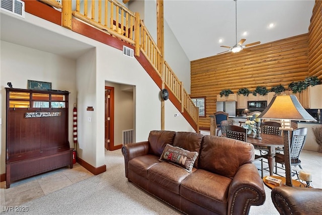 401 Alpine Way, Mount Charleston, NV 89124 - living room with a high ceiling, a ceiling fan, light colored carpet, log walls, and stairway