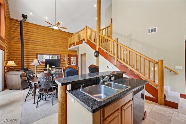 401 Alpine Way, Mount Charleston, NV 89124 - kitchen with dishwasher, a high ceiling, log walls, ceiling fan, and a kitchen island with sink