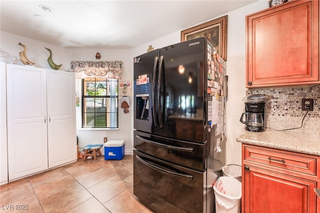1723 Candice St, Las Vegas, NV 89156 - kitchen with black refrigerator with ice dispenser, tasteful backsplash, light stone counters, and light tile patterned flooring