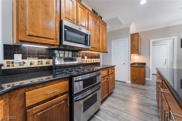 10331 Rio De Thule Ln, Las Vegas, NV 89135 - kitchen featuring stainless steel appliances, crown molding, brown cabinets, light wood-style flooring, and backsplash
