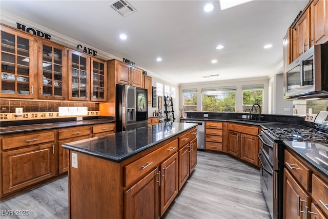 10331 Rio De Thule Ln, Las Vegas, NV 89135 - kitchen with stainless steel appliances, crown molding, recessed lighting, backsplash, and brown cabinetry