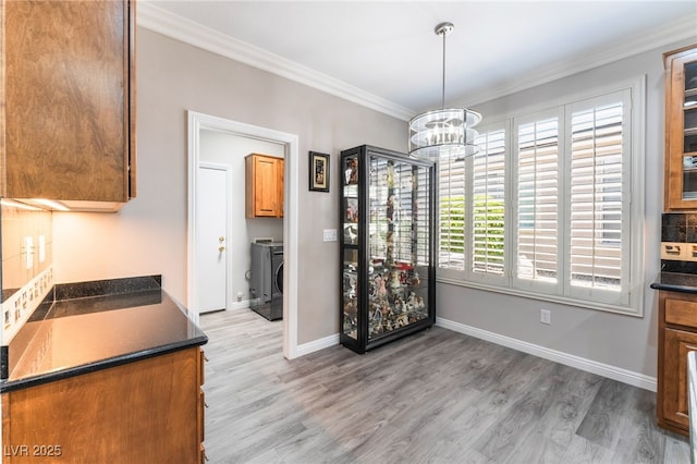 10331 Rio De Thule Ln, Las Vegas, NV 89135 - unfurnished dining area featuring a chandelier, ornamental molding, light wood-style floors, and washing machine and clothes dryer