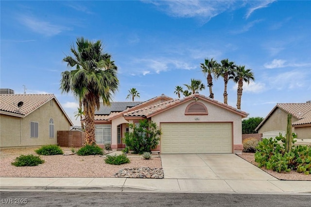 1981 Spring Lake Dr, Henderson, NV 89002 - view of front of home with a garage, solar panels, driveway, stucco siding, and a tile roof
