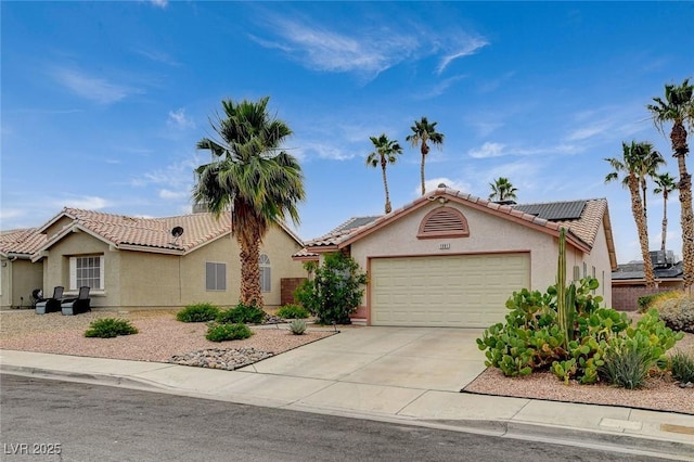 1981 Spring Lake Dr, Henderson, NV 89002 - view of front of house with a garage, solar panels, stucco siding, a tile roof, and driveway