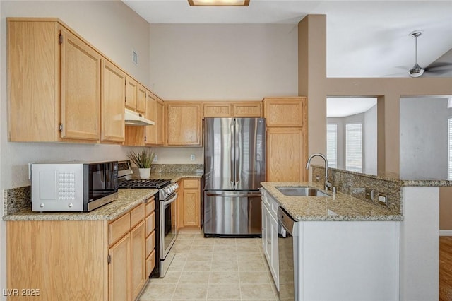 1981 Spring Lake Dr, Henderson, NV 89002 - kitchen featuring stainless steel appliances, under cabinet range hood, light brown cabinets, light stone countertops, and a ceiling fan