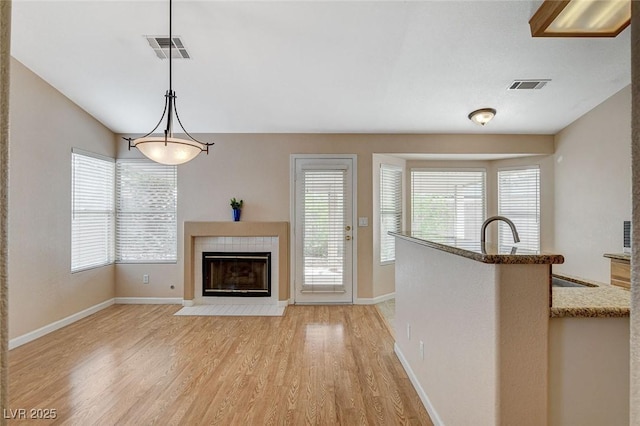 1981 Spring Lake Dr, Henderson, NV 89002 - unfurnished living room with a tile fireplace and light wood-style floors