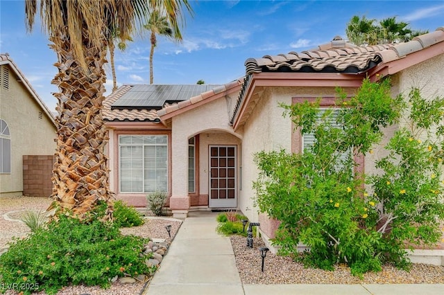 1981 Spring Lake Dr, Henderson, NV 89002 - entrance to property featuring roof mounted solar panels, a tile roof, and stucco siding