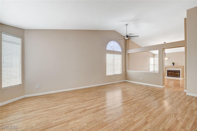 1981 Spring Lake Dr, Henderson, NV 89002 - spare room with a ceiling fan, light wood-style floors, a glass covered fireplace, and vaulted ceiling