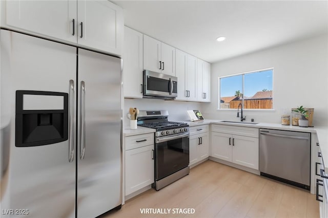 313 Agora Way, Las Vegas, NV 89110 - kitchen with stainless steel appliances, light wood finished floors, white cabinets, light countertops, and recessed lighting