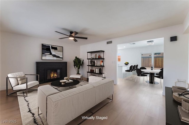 313 Agora Way, Las Vegas, NV 89110 - living room with wood finished floors, a brick fireplace, and a ceiling fan