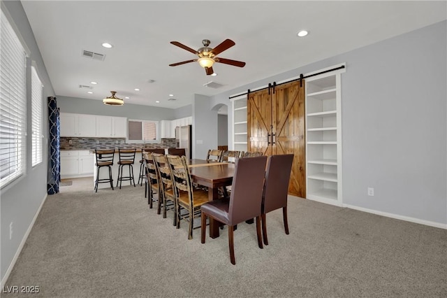 9131 Grand Sunburst Ct, Las Vegas, NV 89149 - dining area with a barn door, a ceiling fan, light carpet, and recessed lighting