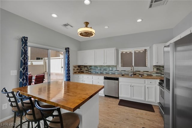 9131 Grand Sunburst Ct, Las Vegas, NV 89149 - kitchen featuring stainless steel appliances, wood counters, decorative backsplash, white cabinetry, and recessed lighting