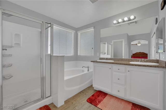 9131 Grand Sunburst Ct, Las Vegas, NV 89149 - full bath featuring a shower stall, wood finished floors, a bath, double vanity, and ensuite bathroom