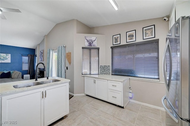 1708 Anzio St, Las Vegas, NV 89108 - kitchen featuring freestanding refrigerator, white cabinetry, ceiling fan, light tile patterned flooring, and vaulted ceiling