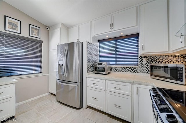 1708 Anzio St, Las Vegas, NV 89108 - kitchen featuring stainless steel appliances, tasteful backsplash, white cabinetry, and healthy amount of natural light