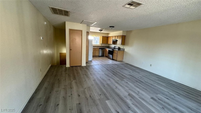 3412 Mercury St Unit I, North Las Vegas, NV 89030 - unfurnished living room with wood finished floors, a textured ceiling, and attic access