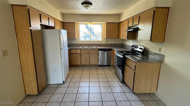 3412 Mercury St Unit I, North Las Vegas, NV 89030 - kitchen with stainless steel appliances, under cabinet range hood, dark countertops, brown cabinetry, and a textured ceiling