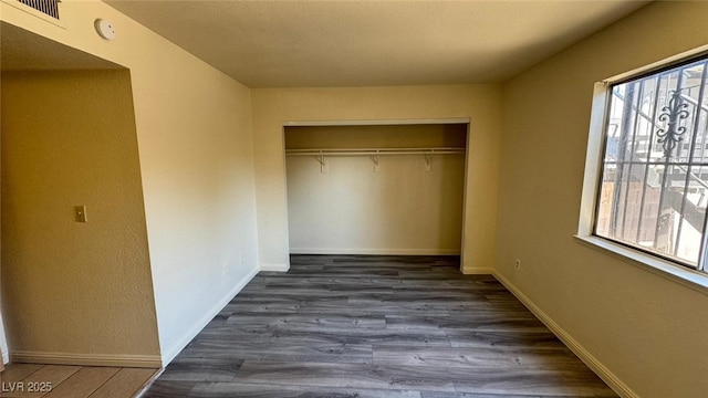 3412 Mercury St Unit I, North Las Vegas, NV 89030 - unfurnished bedroom with multiple windows, a closet, and dark wood finished floors