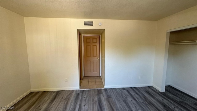 3412 Mercury St Unit I, North Las Vegas, NV 89030 - unfurnished bedroom featuring wood finished floors, a closet, and a textured ceiling