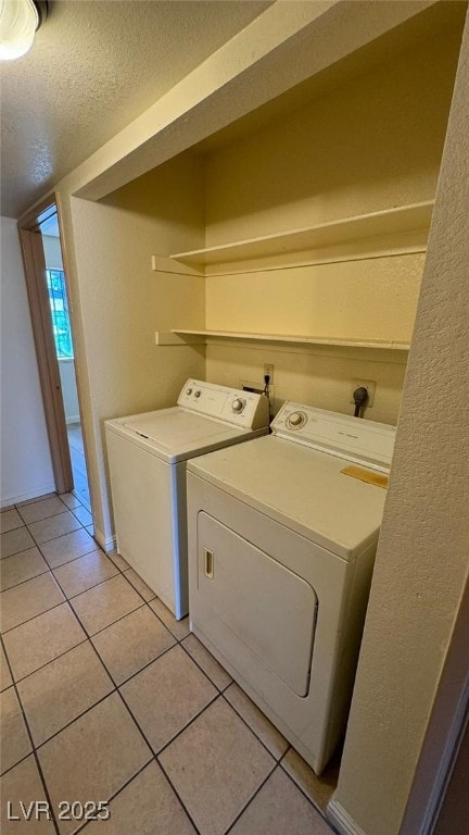 3412 Mercury St Unit I, North Las Vegas, NV 89030 - laundry area featuring washing machine and clothes dryer, light tile patterned floors, and a textured ceiling