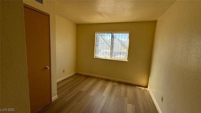 3412 Mercury St Unit I, North Las Vegas, NV 89030 - empty room featuring wood finished floors, a textured wall, and a textured ceiling