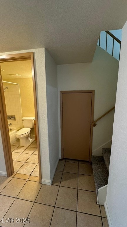 3412 Mercury St Unit I, North Las Vegas, NV 89030 - corridor with light tile patterned floors, a textured ceiling, and stairway