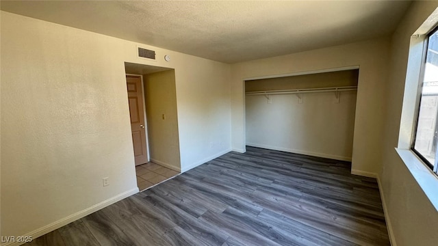 3412 Mercury St Unit I, North Las Vegas, NV 89030 - unfurnished bedroom with wood finished floors, a closet, and a textured ceiling