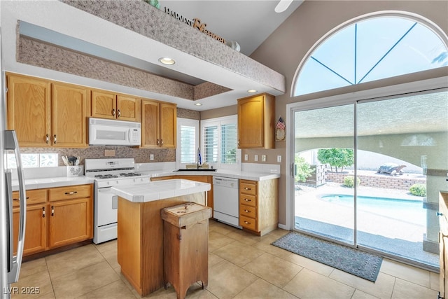 1877 Glory Lily Ct, Las Vegas, NV 89123 - kitchen featuring white appliances, tile countertops, a center island, backsplash, and light tile patterned floors