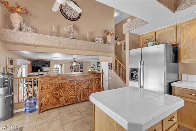 1877 Glory Lily Ct, Las Vegas, NV 89123 - kitchen with ceiling fan, tile counters, stainless steel refrigerator with ice dispenser, open floor plan, and light tile patterned floors