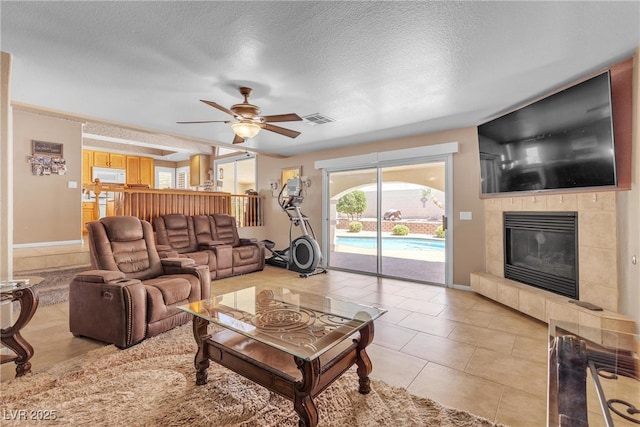 1877 Glory Lily Ct, Las Vegas, NV 89123 - living area with a tile fireplace, ceiling fan, a textured ceiling, and light tile patterned floors