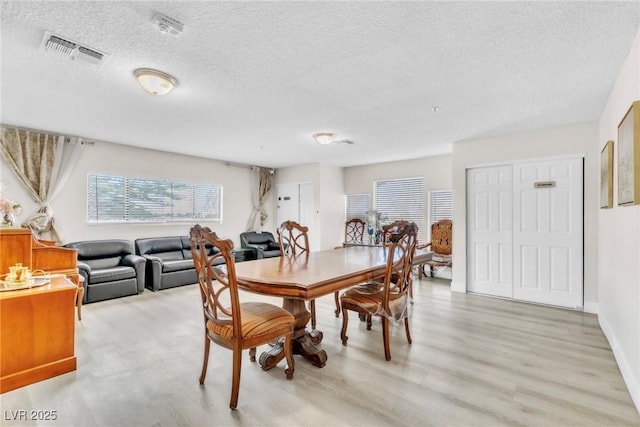 465 E Robindale Rd, Las Vegas, NV 89123 - dining area with light wood-style floors and a textured ceiling