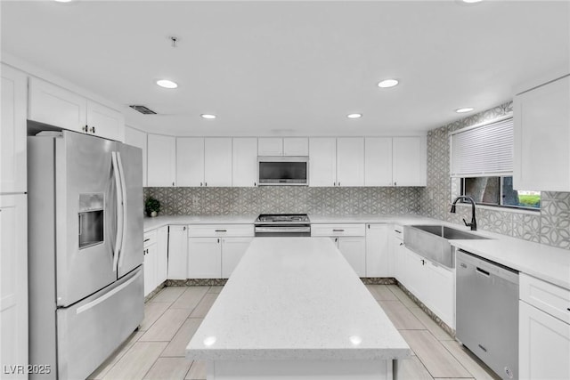 465 E Robindale Rd, Las Vegas, NV 89123 - kitchen featuring stainless steel appliances, a kitchen island, tasteful backsplash, white cabinetry, and recessed lighting