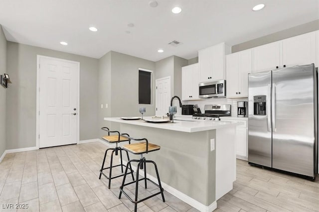 4533 Queens Hill St, North Las Vegas, NV 89031 - kitchen featuring stainless steel appliances, a center island with sink, light wood finished floors, white cabinets, and recessed lighting