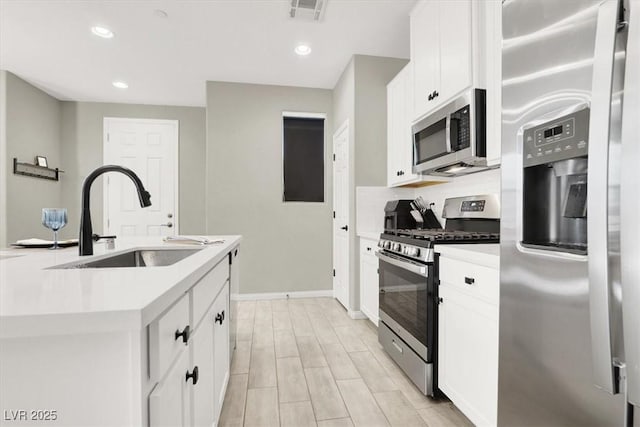 4533 Queens Hill St, North Las Vegas, NV 89031 - kitchen featuring stainless steel appliances, light countertops, white cabinets, recessed lighting, and a kitchen island with sink