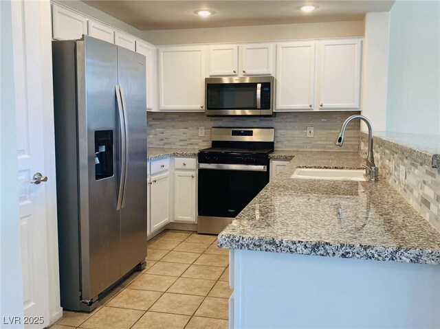 908 Duckhorn Ct Unit 102, Las Vegas, NV 89144 - kitchen featuring stainless steel appliances, decorative backsplash, white cabinets, light tile patterned floors, and recessed lighting