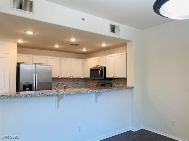 908 Duckhorn Ct Unit 102, Las Vegas, NV 89144 - kitchen featuring stainless steel appliances, light stone counters, white cabinetry, tasteful backsplash, and recessed lighting