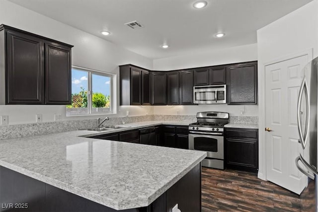 3632 Julia Waldene Ct, Las Vegas, NV 89129 - kitchen featuring appliances with stainless steel finishes, a peninsula, dark wood-type flooring, light countertops, and recessed lighting