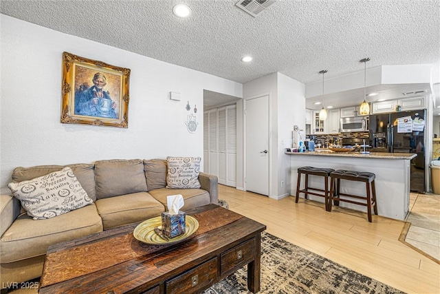 1001 Sulphur Springs Ln Unit 202, Las Vegas, NV 89128 - living area with a textured ceiling, light wood-type flooring, and recessed lighting