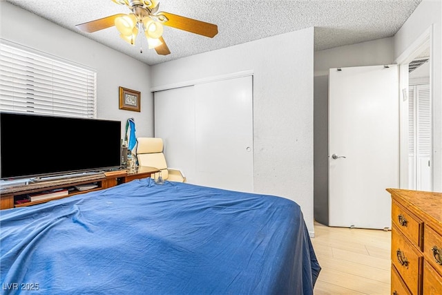 1001 Sulphur Springs Ln Unit 202, Las Vegas, NV 89128 - bedroom with a closet, a textured ceiling, ceiling fan, and light wood-style flooring