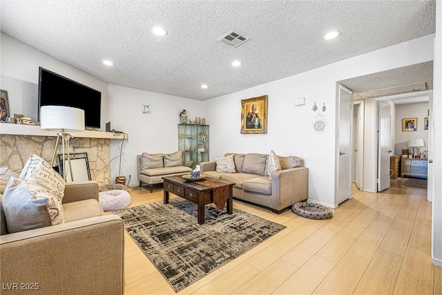 1001 Sulphur Springs Ln Unit 202, Las Vegas, NV 89128 - living room featuring a textured ceiling, recessed lighting, and light wood-style flooring