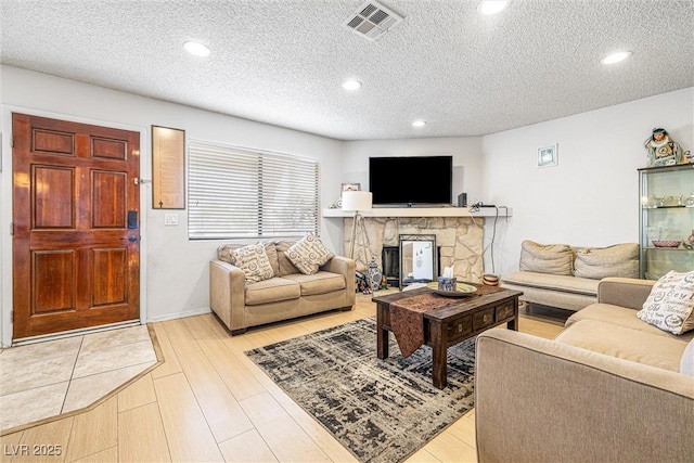 1001 Sulphur Springs Ln Unit 202, Las Vegas, NV 89128 - living area with a textured ceiling, light wood-style flooring, recessed lighting, and a fireplace